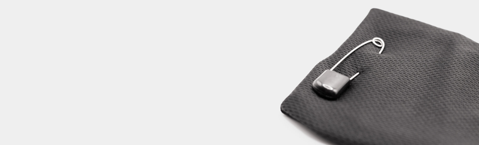 A safety clip on a black joey laying on a white background