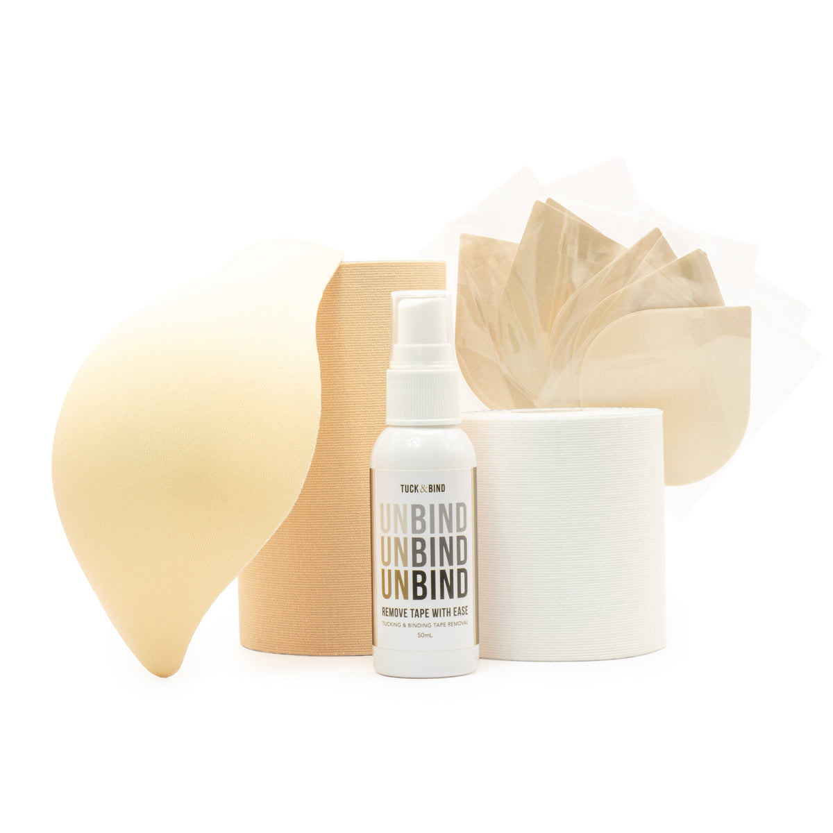 A product kit containing a bottle of Tuck & Bind Unbind, a roll of 5
beige trans tape, a roll of 3' white chest trans tape, a beige foam packer, and nipple covers, all arranged on a clean white background.