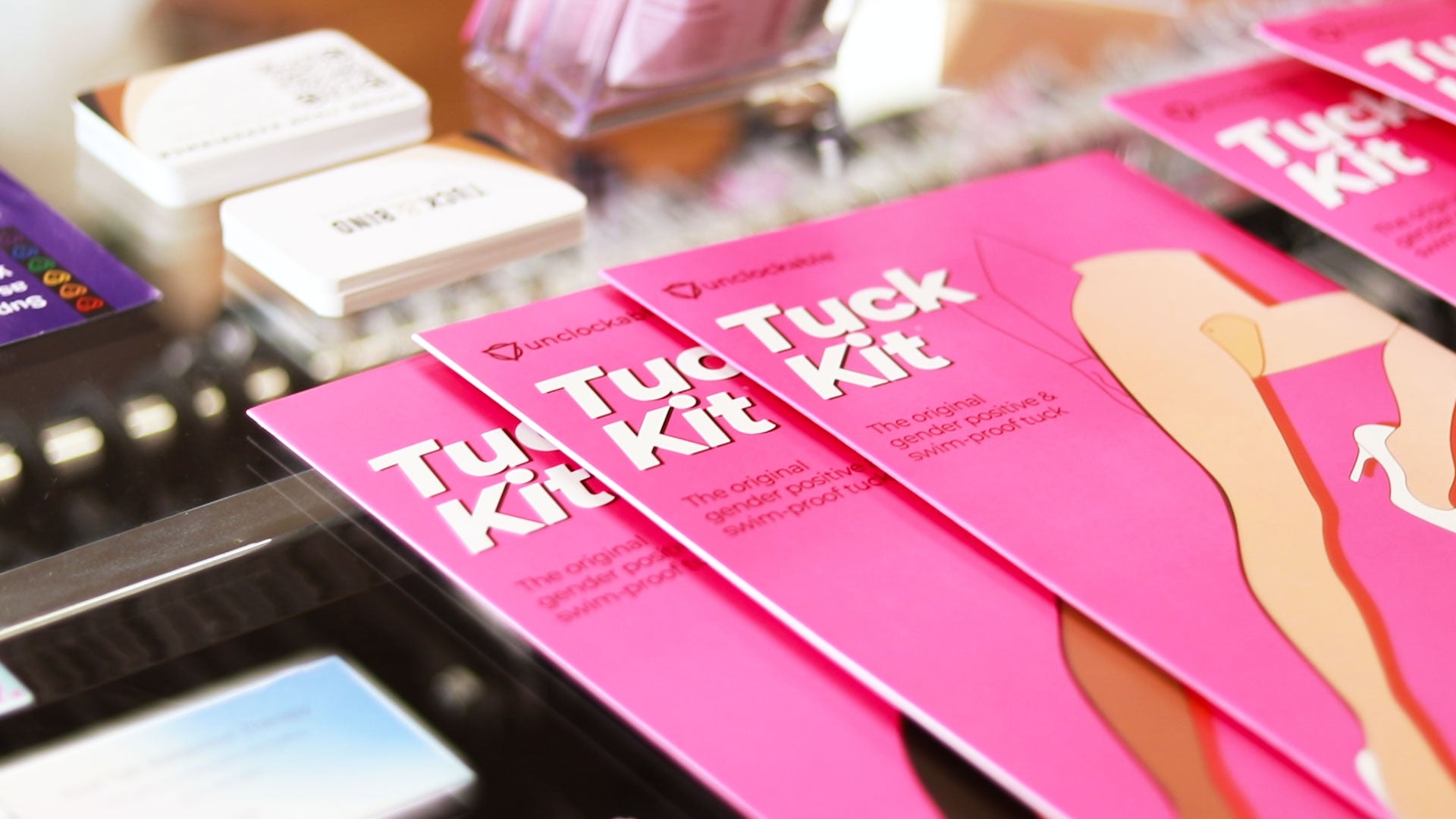 Pink Unclockables ’tuck kit’ product packaging with a stylized illustration of legs in high heels.