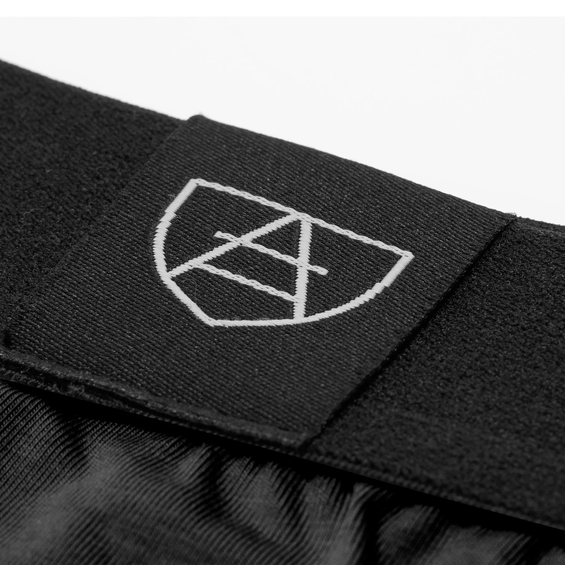 Black elastic waistband with white embroidered shield logo on All-In-One Packing Briefs