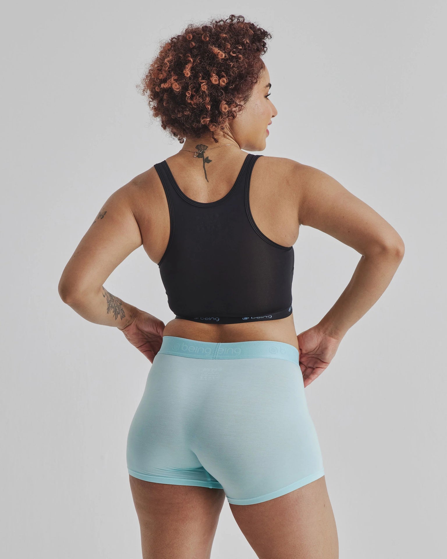 Black racerback sports bra with light blue waistband in Being Wear Binder