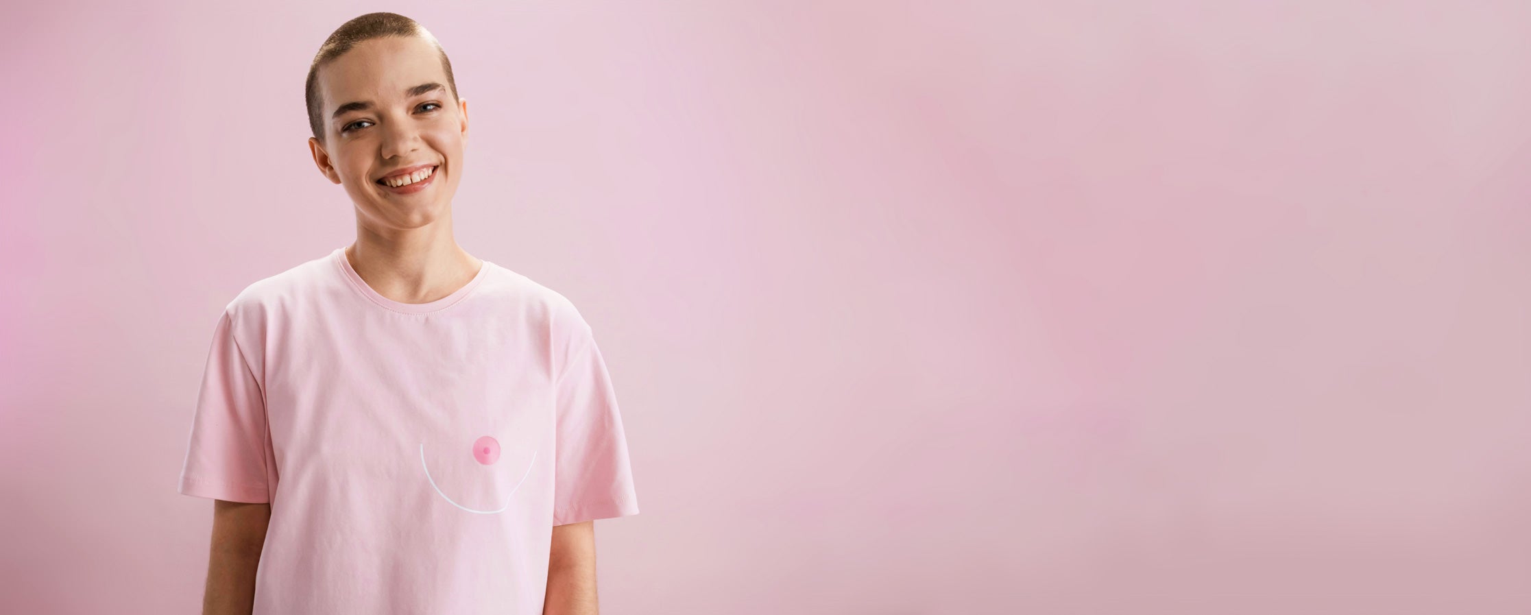 Person wearing a tshirt with a mastectomy icon on a pink background