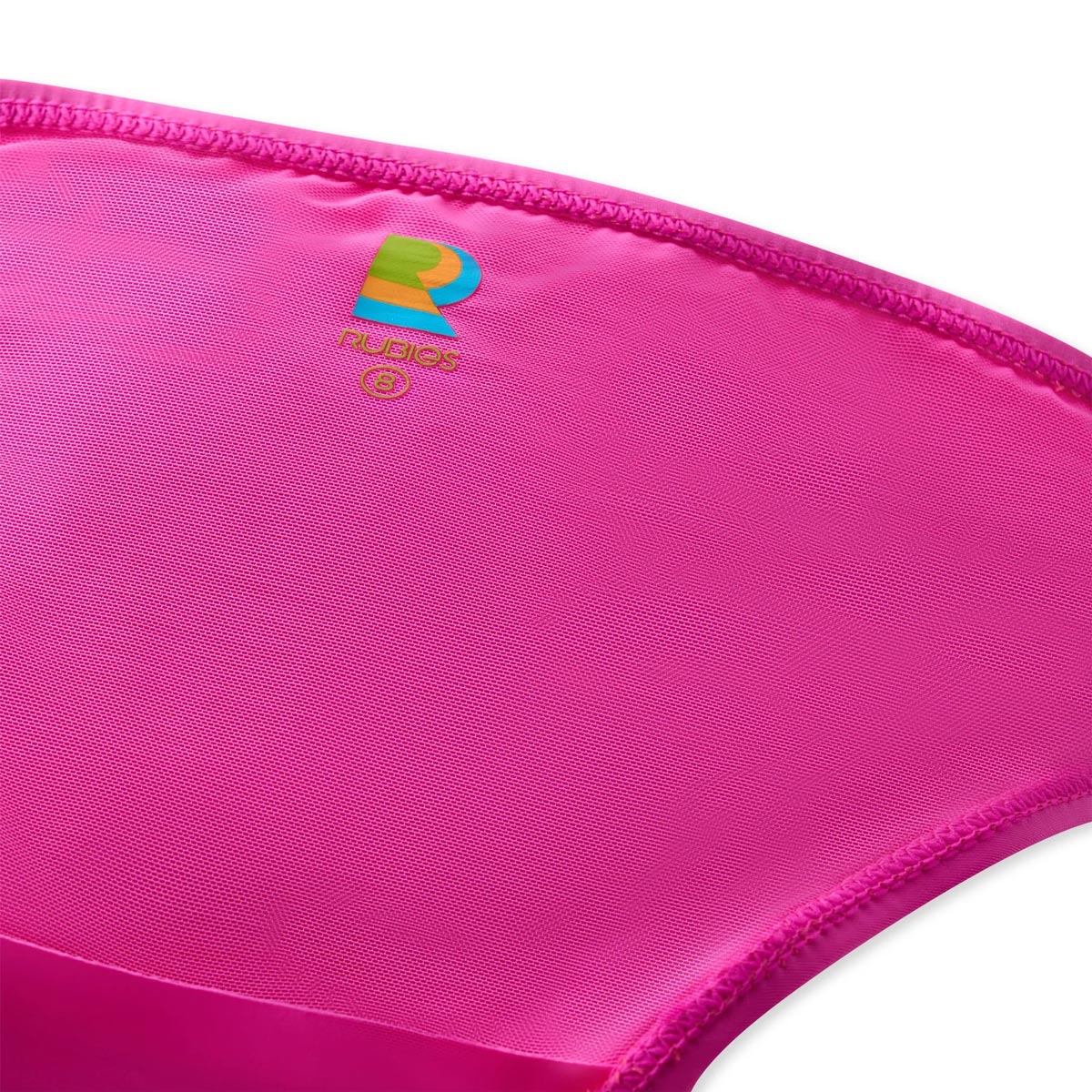 Close-up of bright pink bikini fabric with a small multicolor Rubies logo and the word Rubies printed near the center, shown against a white background.