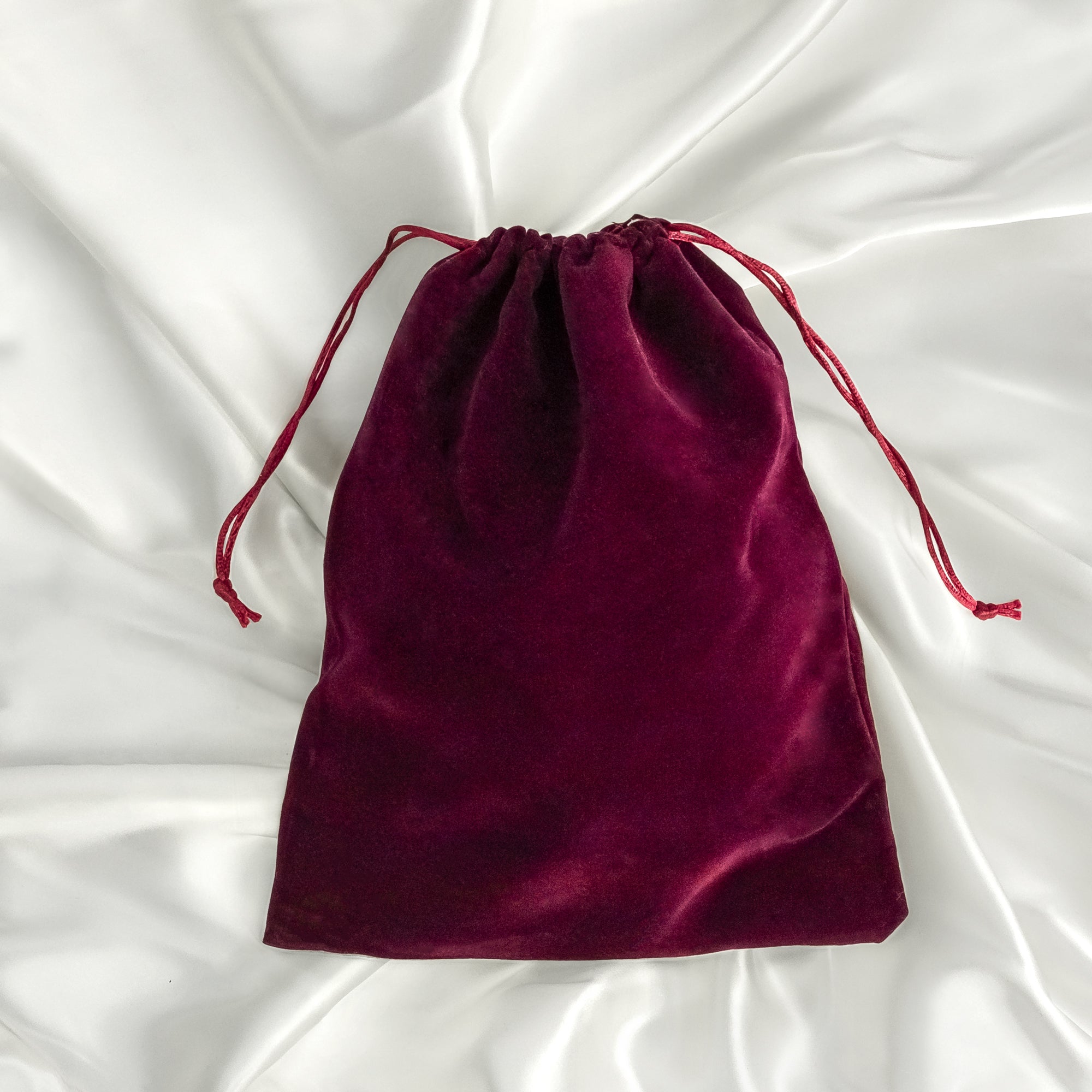 burgundy breast form pouch on silk background