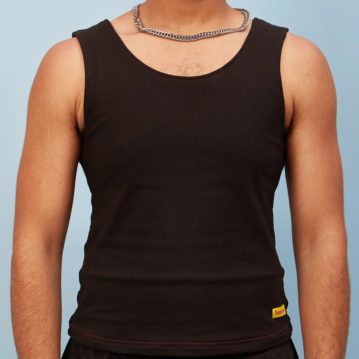 Person wearing a black chest binder tank top