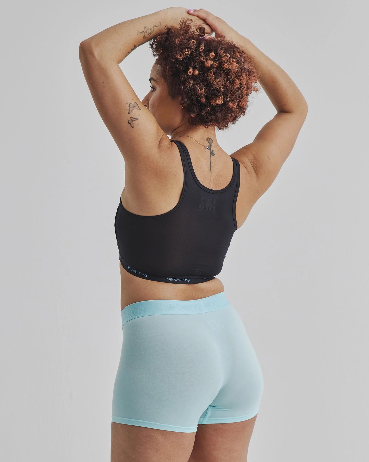 Black Being Wear Binder sports bra with blue high-waisted shorts